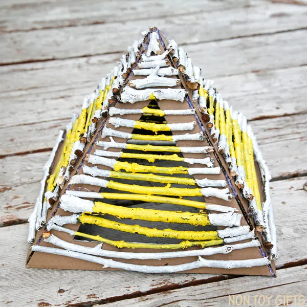 Building pyramids with nature elements (sticks and twigs) is a great craft for preschoolers. They learn architecture, Egypt's history and express their creativity through paint. Place a flameless candle underneath the pyramid and it makes a great lantern. Stick pyramid - nature craft | at Non Toy Gifts