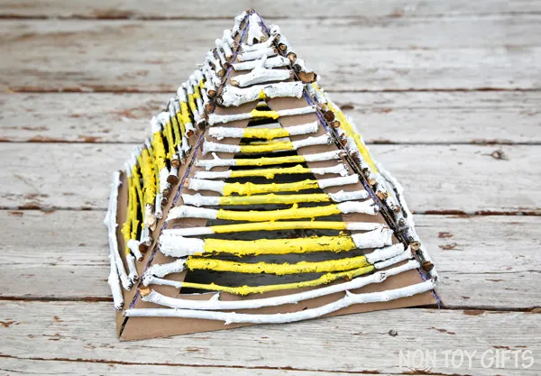 Building pyramids with nature elements (sticks and twigs) is a great craft for preschoolers. They learn architecture, Egypt's history and express their creativity through paint. Place a flameless candle underneath the pyramid and it makes a great lantern. Stick pyramid - nature craft | at Non Toy Gifts