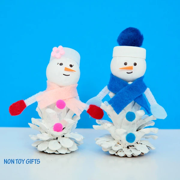 Pine cone snow friends. A snowman and snow woman craft for kids to try this winter when it's too cold to play outside. | at Non Toy Gifts
