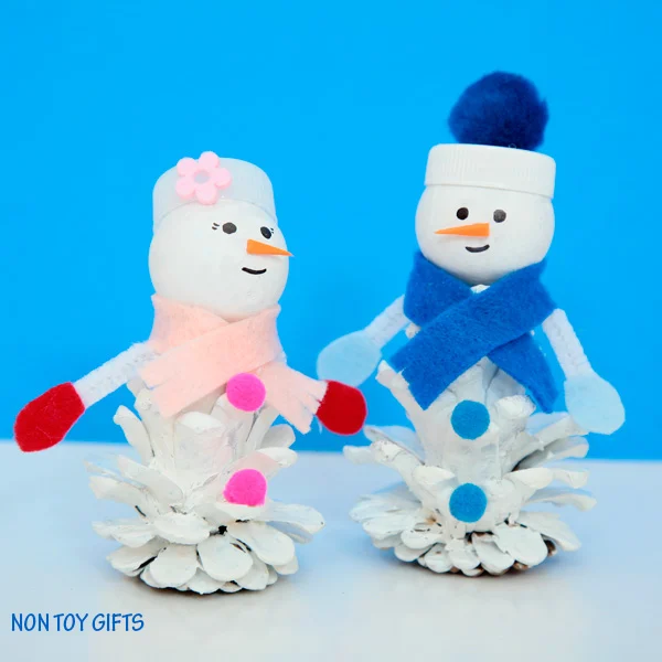 Pine cone snow friends. A snowman and snow woman craft for kids to try this winter when it's too cold to play outside. | at Non Toy Gifts