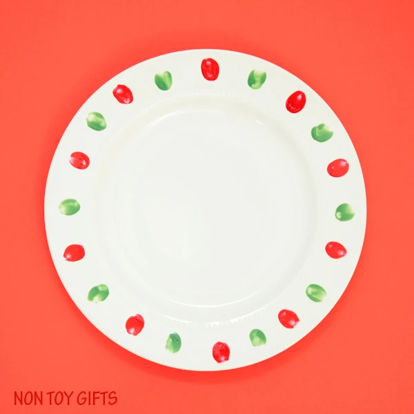 This Christmas plate gift is a fun and easy kid-made present for grandparents, babysitter or teacher. Use this fingerprint Christmas light craft idea also for mugs or bowls. | at Non-Toy Gifts