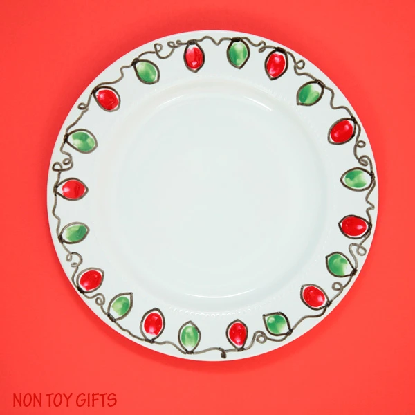 This Christmas plate gift is a fun and easy kid-made present for grandparents, babysitter or teacher. Use this fingerprint Christmas light craft idea also for mugs or bowls. | at Non-Toy Gifts