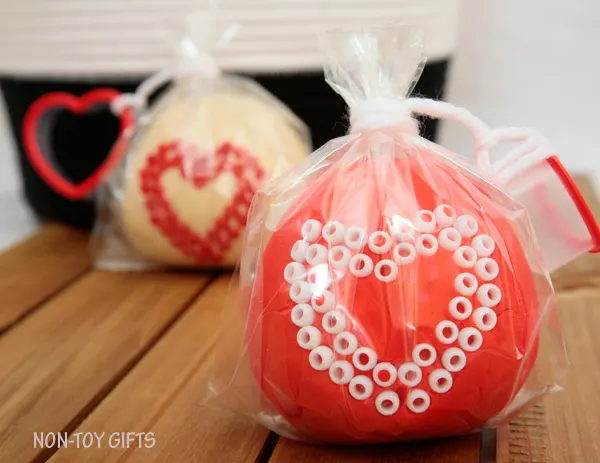 These play dough Valentines make great Valentine non-candy treats for preschool and kindergartner classroom party. Fun Valentine's Day activity for kids. Use heart shaped cookie cutter and decorate with beads | at Non-Toy Gifts
