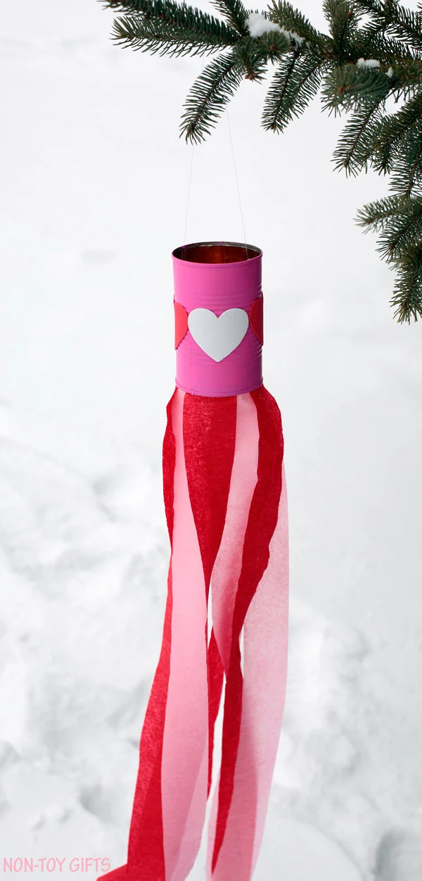 Valentine easy kids craft: heart windsocks. Use tin can, heart stickers, paint and crepe streams to make this DIY Valentine's Day decoration. Perfect craft for preschool or kindergarten. | at Non-Toy Gifts