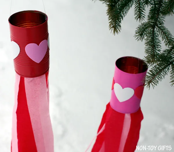 Valentine easy kids craft: heart windsocks. Use tin can, heart stickers, paint and crepe streams to make this DIY Valentine's Day decoration. Perfect craft for preschool or kindergarten. | at Non-Toy Gifts