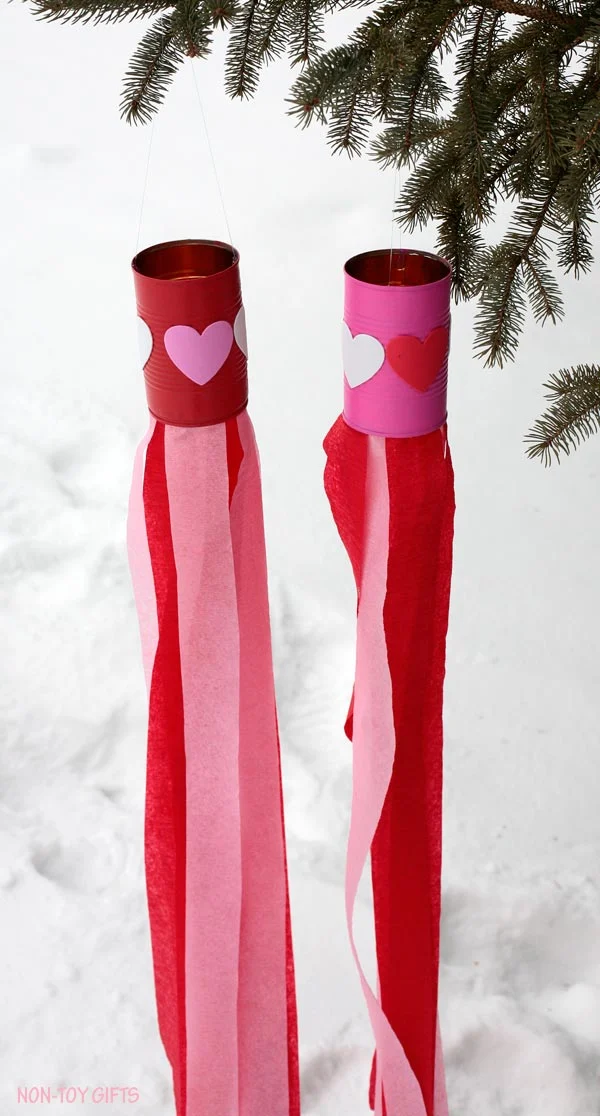 Valentine easy kids craft: heart windsocks. Use tin can, heart stickers, paint and crepe streams to make this DIY Valentine's Day decoration. Perfect craft for preschool or kindergarten. | at Non-Toy Gifts