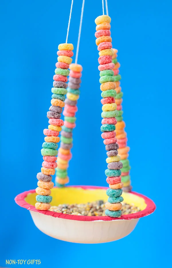 Paper bowl bird feeder for kids to make this spring. Watch birds in your own backyard. Made with Cheerios, this kid-made bird feeder is perfect for preschoolers and kindergarten. | at Non-Toy Gifts