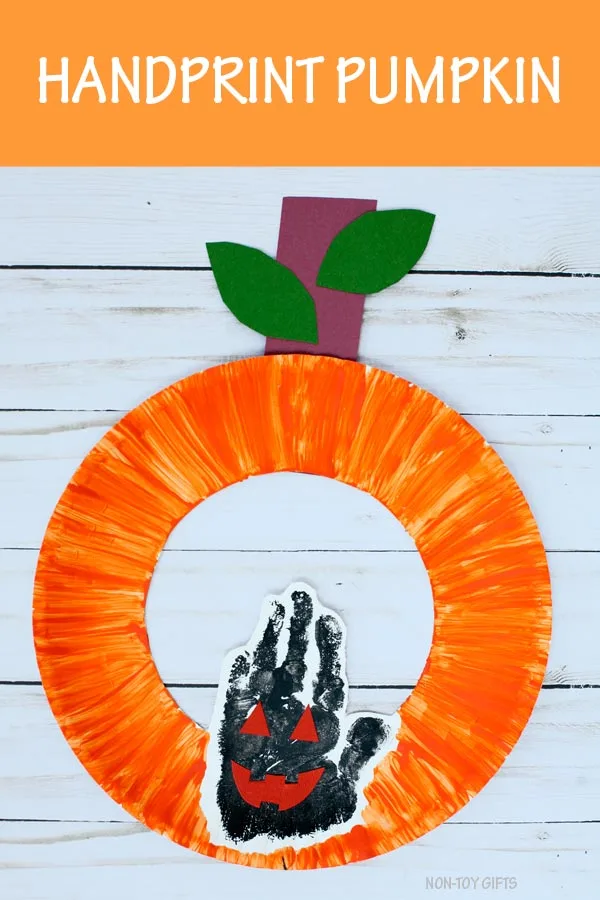 Handprint pumpkin craft for kids to make for Halloween with a paper plate