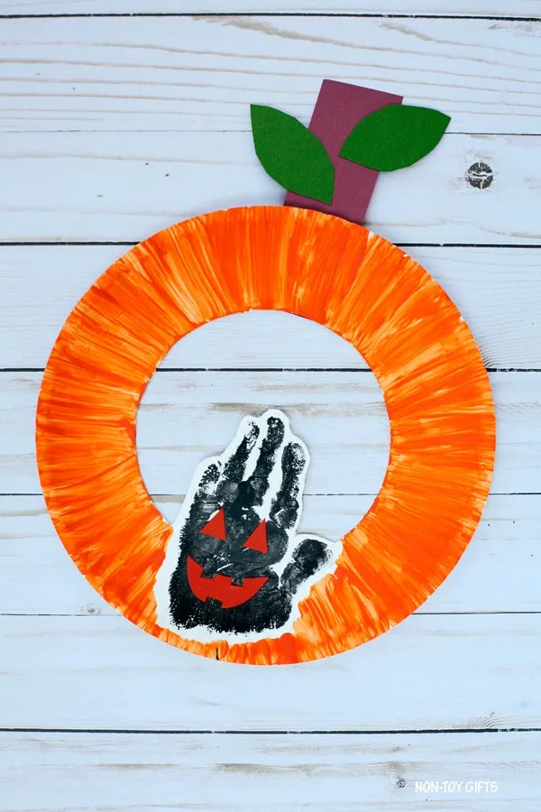 Paper plate Jack'O'Lantern craft for kids. Handprint pumpkin